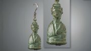Bronze weight shaped as a bust of an empress, featuring intricate details and a hook for hanging.