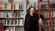 Wendy Lesser standing happily among her books