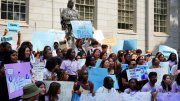 Photograph of student rally against the Supreme Court decision with the John Harvard statue in the background