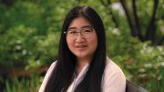 Vivian W. Rong sitting on bench outdoors.