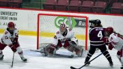 Photograph of several players competing for the puck in front of the Harvard goal