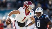 Harvard quarterback evading a defender during a football game.