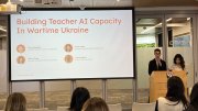 Two students stand in front of a presentation as they deliver a talk