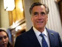 Mitt Romney in a suit, with a decorative background and natural lighting.