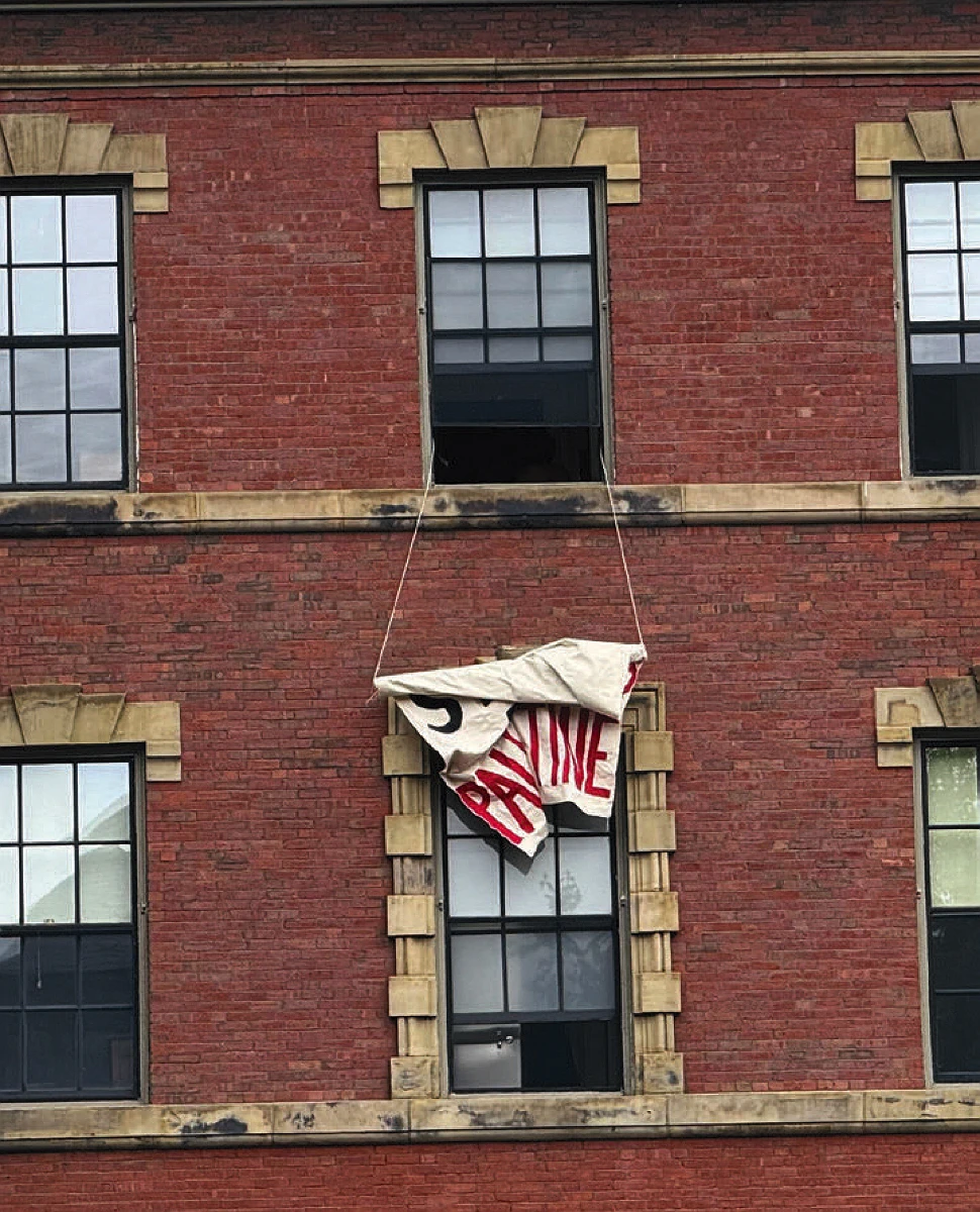 A protest sign rolled up, outside of a window