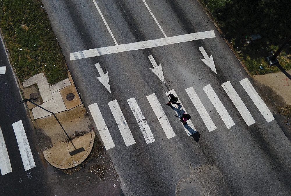An aerial view of pedestrians crossing Philadelphia’s Roosevelt Boulevard with multiple wide lanes and crosswalks.