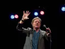 Jimmy Tingle holding a microphone and performing on stage