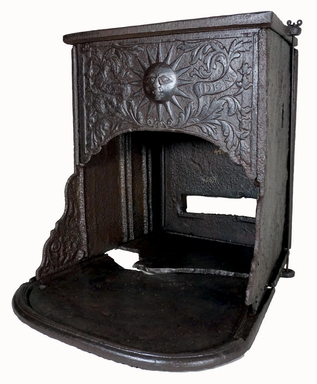 Early Franklin stove with embossed sun face and scrollwork on cast-iron panel