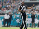 NFL referee Ron Torbert in uniform on the football during a game