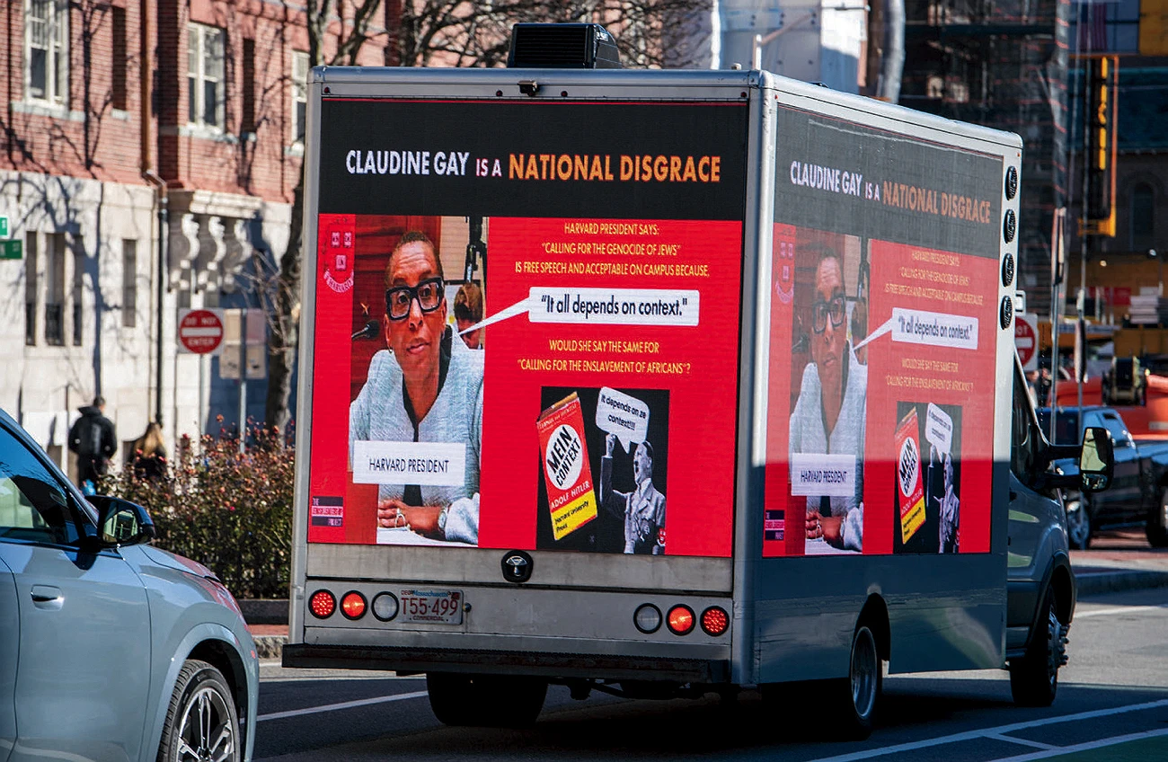 Truck billboard criticizing Claudine Gay with quotes on antisemitism and an image of Adolf Hitler's book. Message on the truck: "Claudine Gay is a National Disgrace; Harvard President says: 'Calling for the Genocide of Jews' is free speech and acceptable on campus because 'It all depends on context.' would she say the same for 'Calling for the enslavement of africans?'"