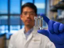 A scientist holds up an experiment item